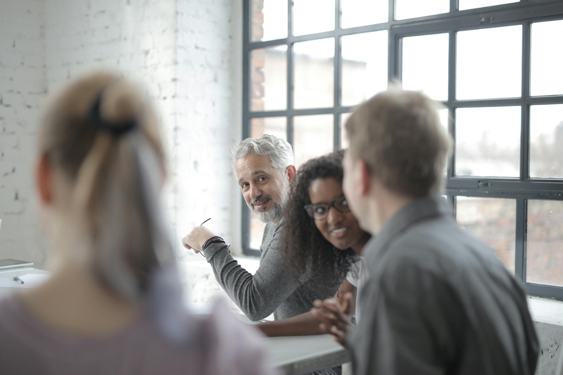 multiracial colleagues of different ages having informal conversation in office