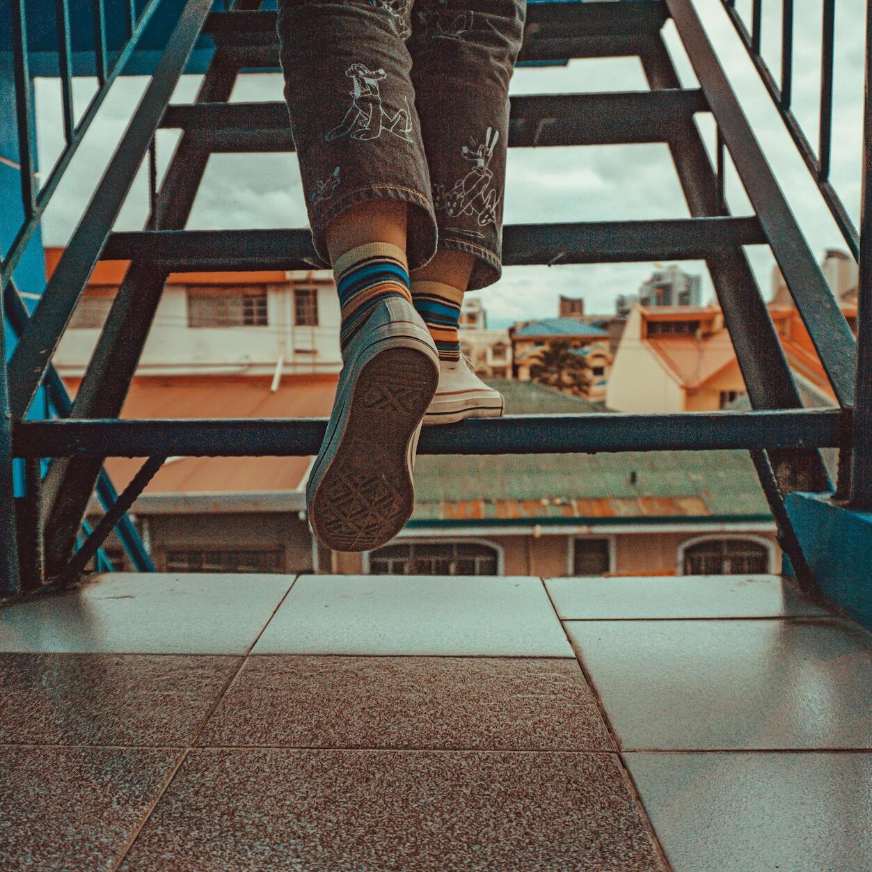 person wearing rainbow socks while walking upstairs